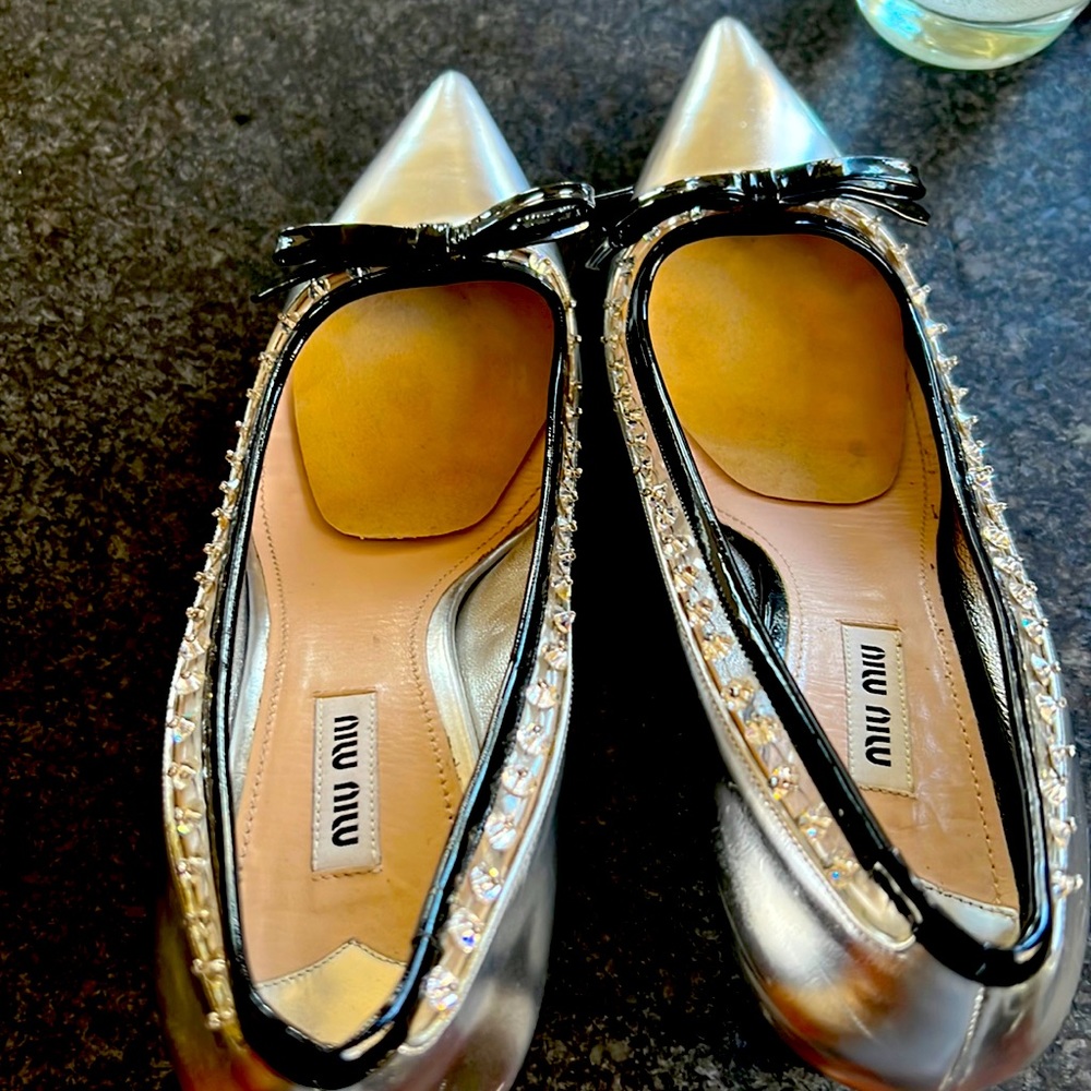 Miu Miu pumps in silver. Patent black bow w/rhinestone detail. Size 39.